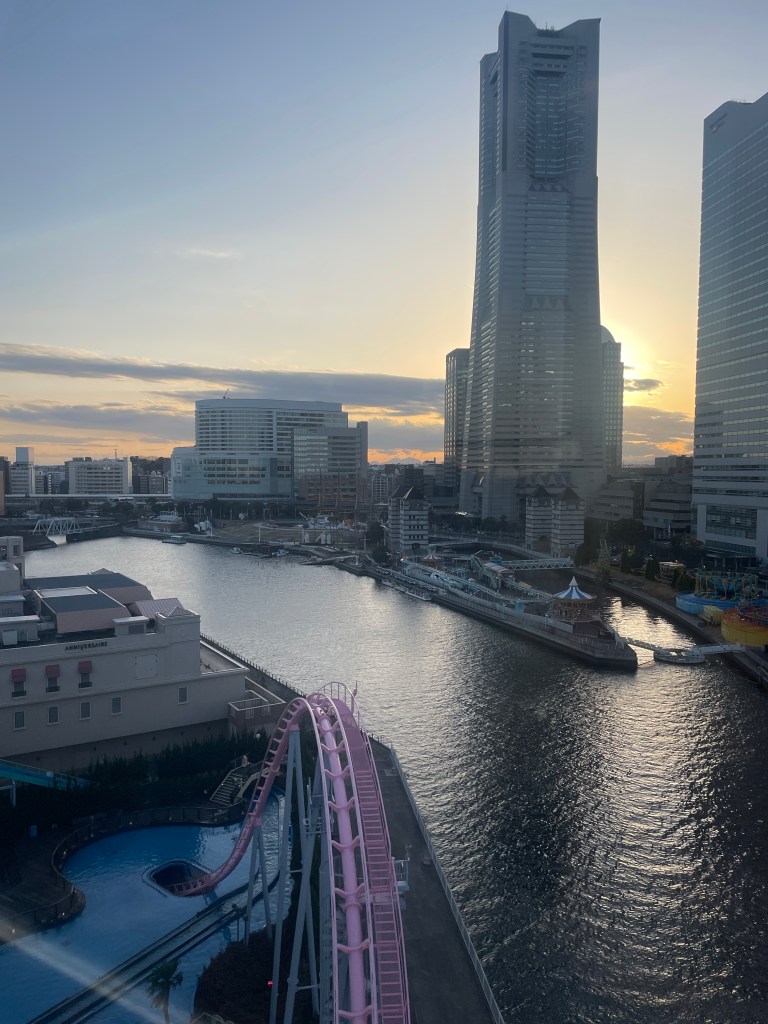 Photo taken from Cosmo Clock showing Yokohama's city skyscraper buildings, the harbour and a Cosmo World rollercoaster.
