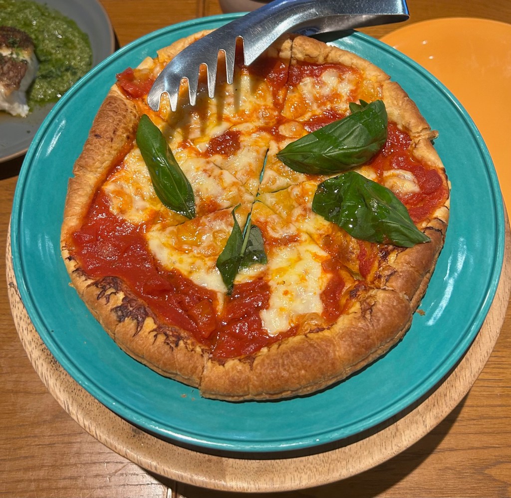 Margherita pizza on a blue plate. The pizza's base is puff pie pastry.